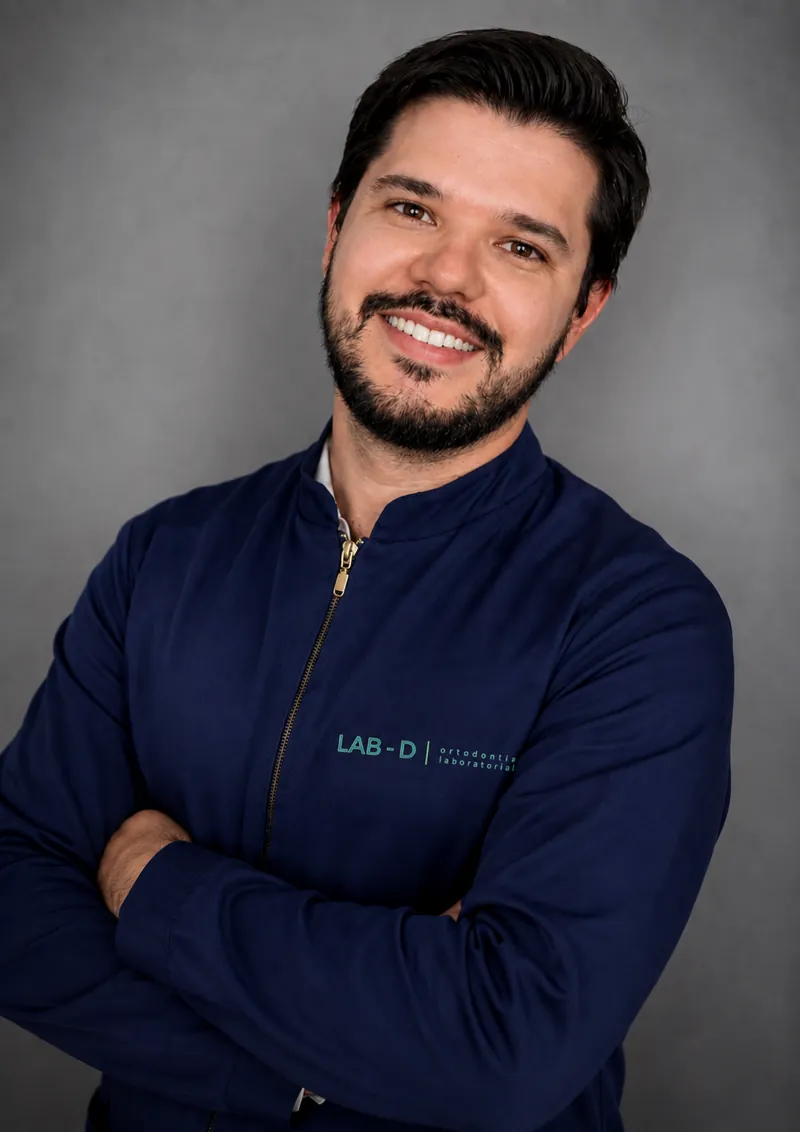 Denizard Amaral, técnico em prótese dentária responsável pelo LAB-D, de braços cruzados com o jaleco do laboratório